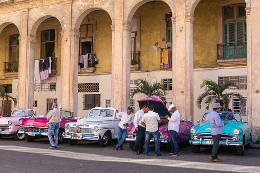 Traditional and colorful old taxi cars with old buildings in the background. Havana's vintage cars are now one of the city's top tourist brands.
