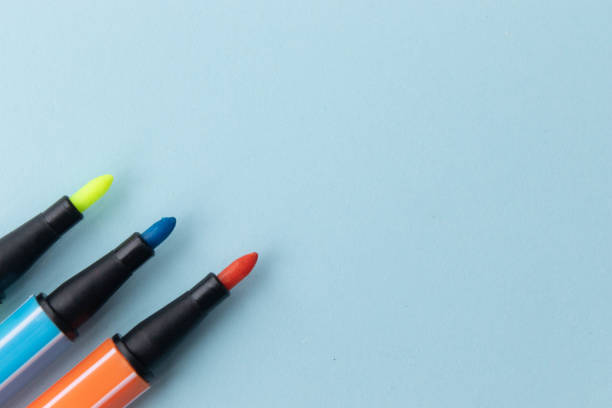 istock Yellow, orange and blue felt-tip pens on light blue background. Flat lay top view with copy space. 1256363208
