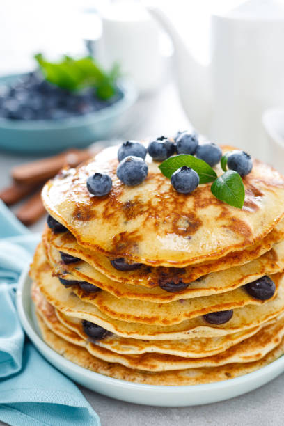 Blueberry pancakes with butter, maple syrup and fresh berries. American breakfast