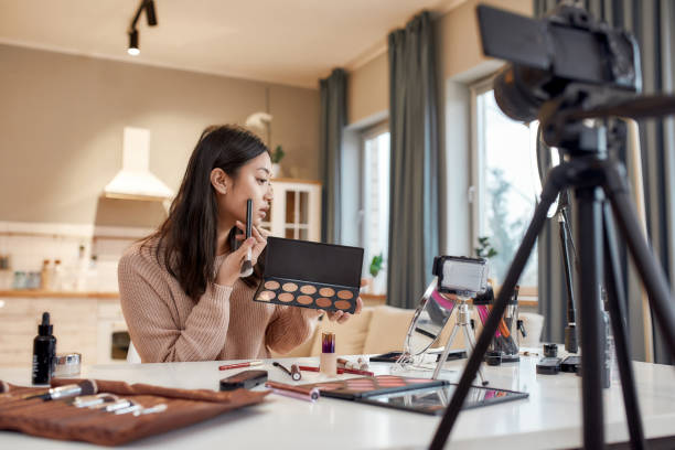 istock All for being a girl. Young female blogger applying makeup, testing cosmetic products while recording a tutorial video for her beauty blog using camera at home 1256366208