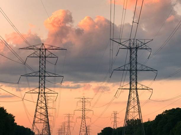 istock Large metal electric tower at sunrise with dramatic colourful clouds and  sky 1256366218