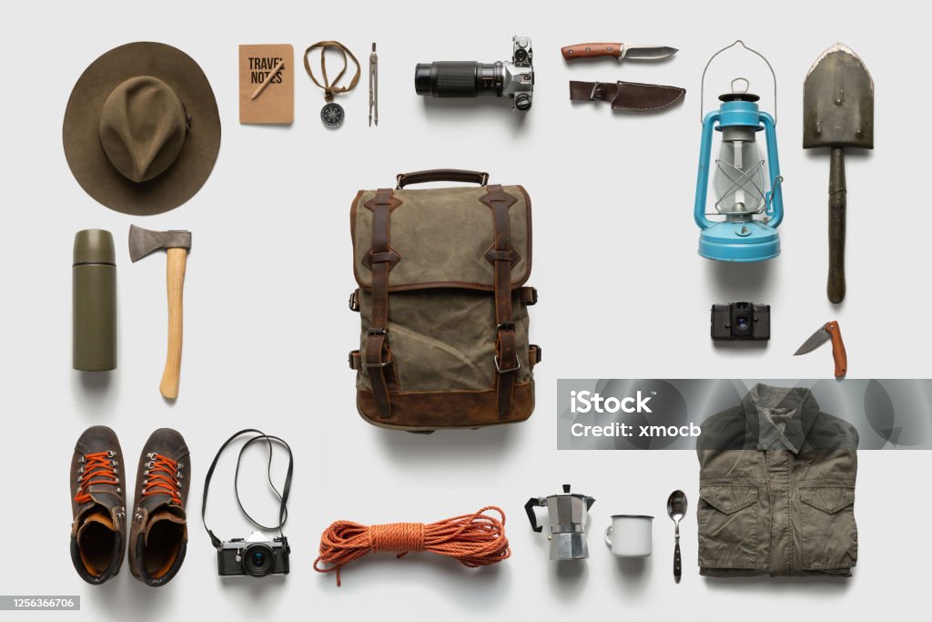 Packing backpack for a trip concept with traveler items isolated on white background Traveler set on white background isolated. Packing backpack for a trip creative concept. Camping Stock Photo