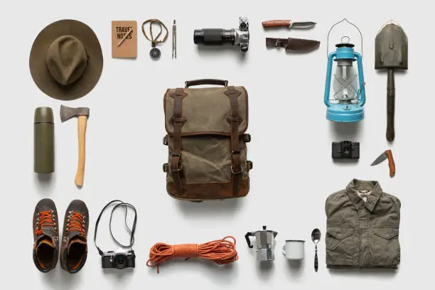 Photo of Packing backpack for a trip concept with traveler items isolated on white background