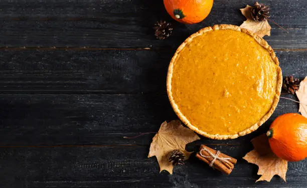 Pumpkin pie for thanksgiving top view on wooden table with copy space