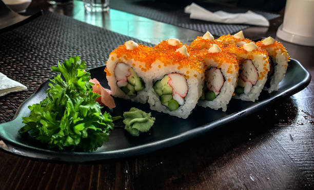 california uramaki, prato de sushi com crabstick, camarão, ovo doce, aspargos e rolo de pepino coberto com tobiko - sushi chopsticks sushi bar food - fotografias e filmes do acervo
