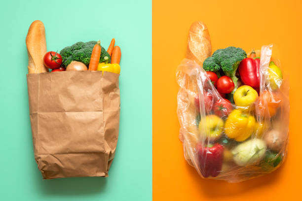 Grocery bags, paper versus plastic. Plastic-free shopping concept Top view with groceries in plastic and paper bags on a bicolored background. Concept for plastic-free shopping. Choosing between paper and plastic bags. paper bag stock pictures, royalty-free photos & images