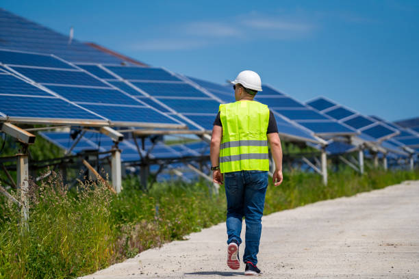 engeneer in worker helmet on solar panels background. solar power panel. green energy. electricity. power energy pannels. - automatically imagens e fotografias de stock