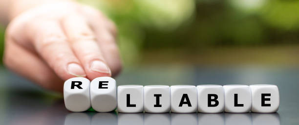 istock Hand turns dice and changes the word liable to reliable. 1256371179
