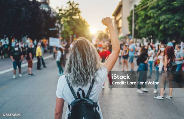 Young Woman Protester Raising Her Fist Up Stock Photo - Download Image Now - Protest, Women, Women's Rights
