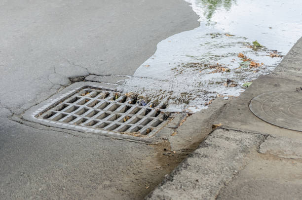 istock Water drains into a storm drain on the road close-up 1256375821