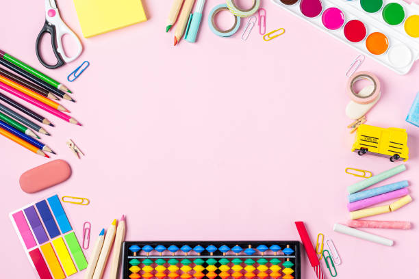 istock Flat lay of modern pink office desktop with school supplies on table around empty space for text. Top view Back to school concept. Copy space. 1256376040