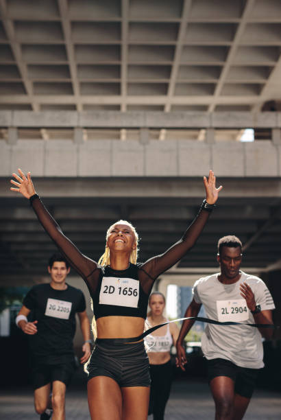 istock Winning athlete crosses the finish line 1256376231