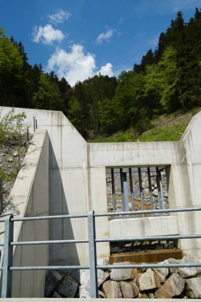 istock Concrete wall and netal grid protecting the forest brook basin and the valley from dtobes coming with strong stream when snow melts in the Alps. Region Engelberg in Switzerland. 1256376870