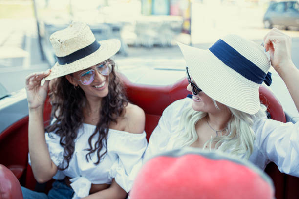 istock Two attractive young girls in cabriolet 1256377357