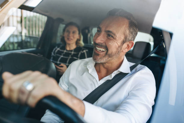 tassista che parla con una passeggera in auto - montato foto e immagini stock