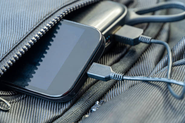 istock Smartphone charging with black energy bank in backpack 1256378120