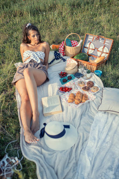 istock Brunette young woman on a picnic reading a book 1256378125