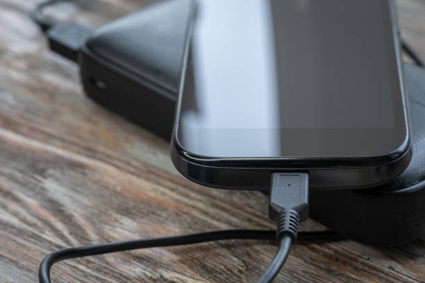 istock Smartphone charging with power bank on wood board 1256378213