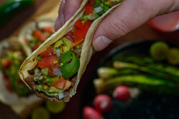 istock Tijuana tacos, lifting grilled carne asada taco 1256379173