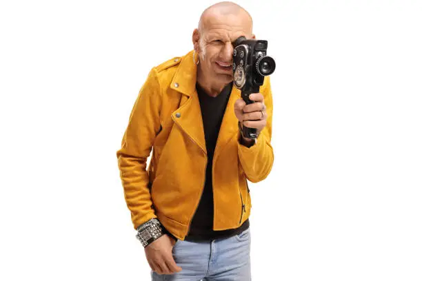 Bald hipster guy filming with a vitnage camera recorder isolated on white background