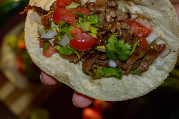 istock Mexican tacos, holding grilled carne asada taco 1256380229
