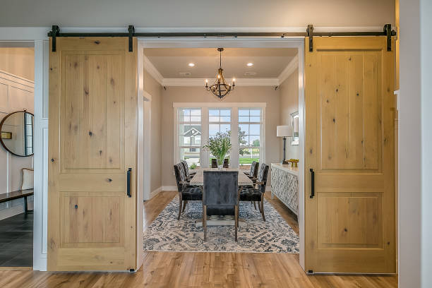 Exquisite dining room with double barn door entrance Beautiful wood barn doors and hardwood flooring give an elegant but down to earth type of feel chandelier photos stock pictures, royalty-free photos & images