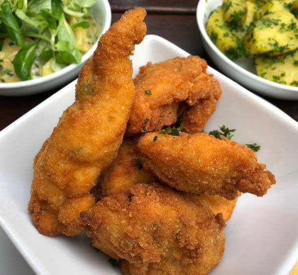 istock Breaded fried chicken with parsley potatoes and potato salad. 1256386412