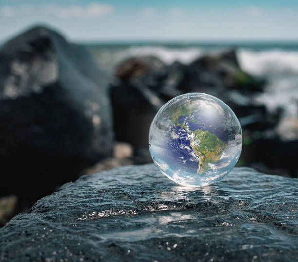istock Crystal ball reflecting globe of the earth in beach 1256387906