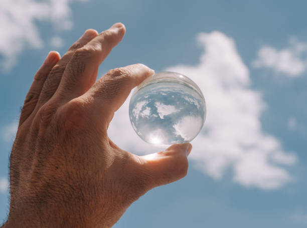 istock Hand holding clouds reflection in crystal ball 1256388935
