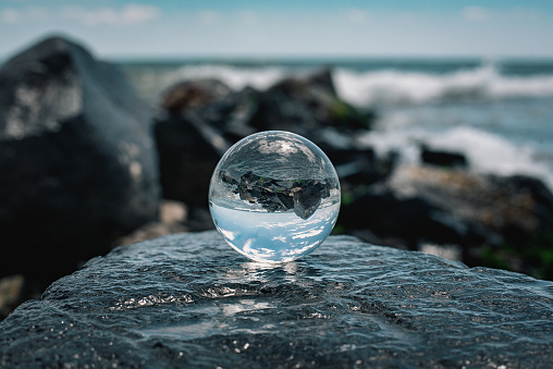 Seascape reflecting in a glass ball on the beach