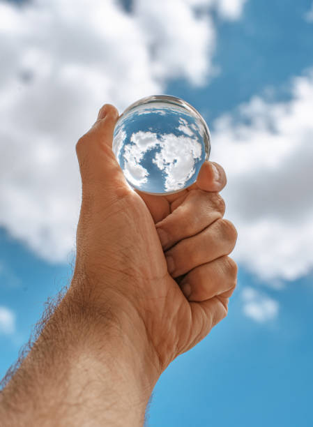 istock Hand holding clouds reflection in crystal ball 1256389746