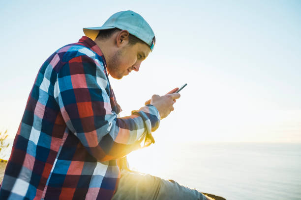 istock Young man relaxes by waterfront at sunrise 1256393551
