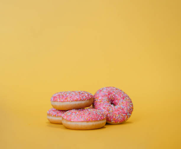 istock Pink donuts on yellow background and copy space 1256394208
