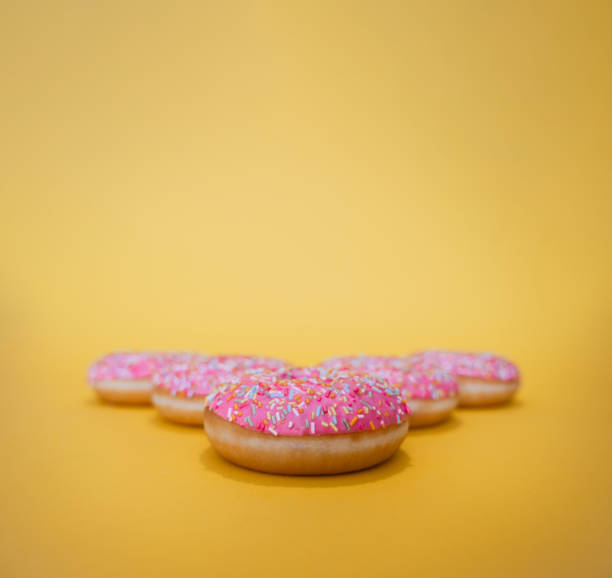 istock Pink donuts on yellow background and copy space 1256394213