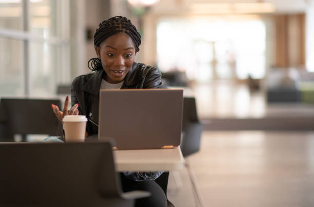 istock Black woman working at desk on video call, drinking coffee 1256397573