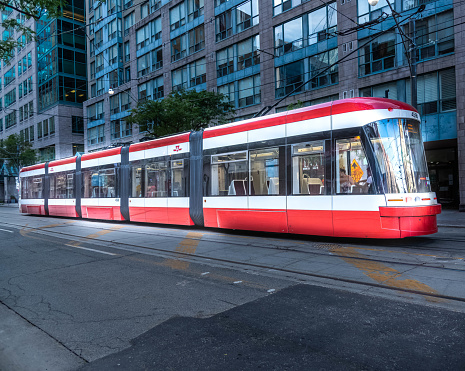 A TTC street car stopped in traffic in downtown Toronto. On the other side of the street car, it’s picking up passengers.