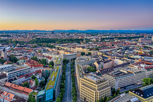 Aerial view over Munich with offices and houses and the alp mountains in the background.