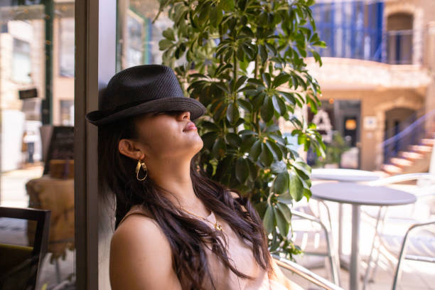 Young woman sleeping in cafe, the face is covered by hat