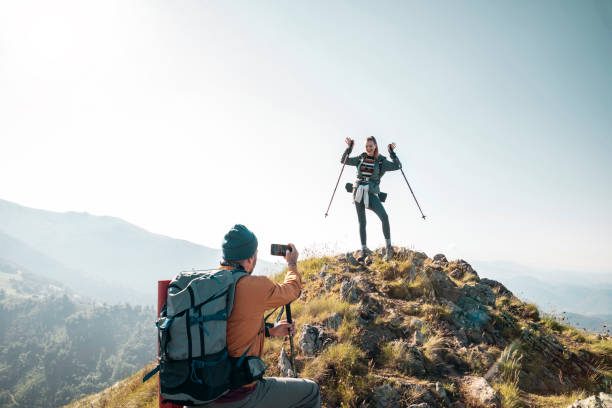 istock Young couple taking pictures while out hiking 1256404976