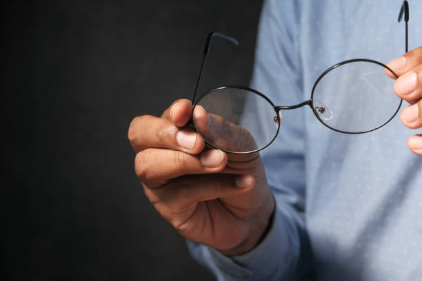 istock Black Eye Glasses in hand Isolated on black 1256416007