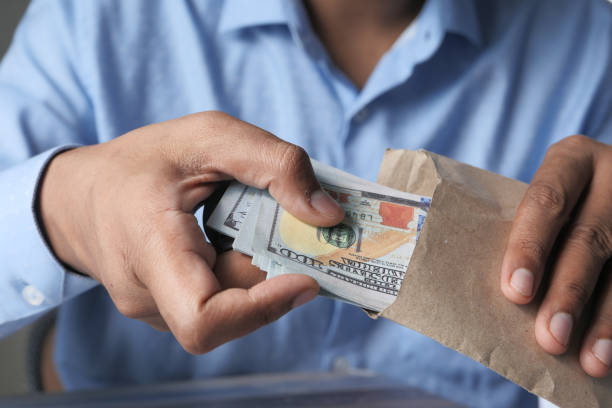 istock person hand putting cash in a envelope 1256416070