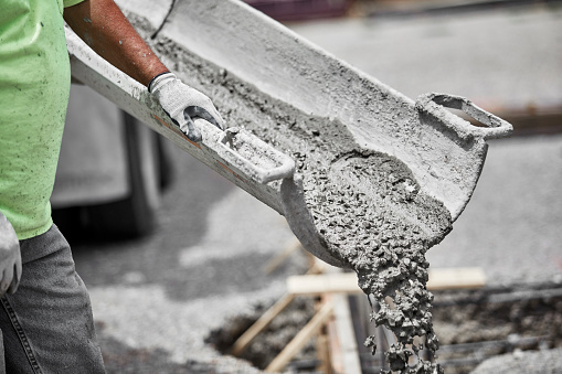 Construction worker holding the cement shute for a pour