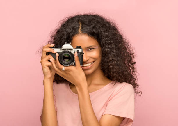 istock Happy young black woman with vintage camera 1256420430
