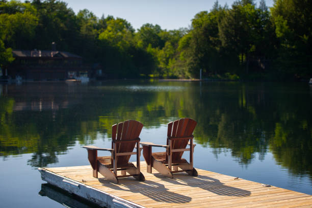 istock Adirondack chairs sitting on a wooden pier 1256422195