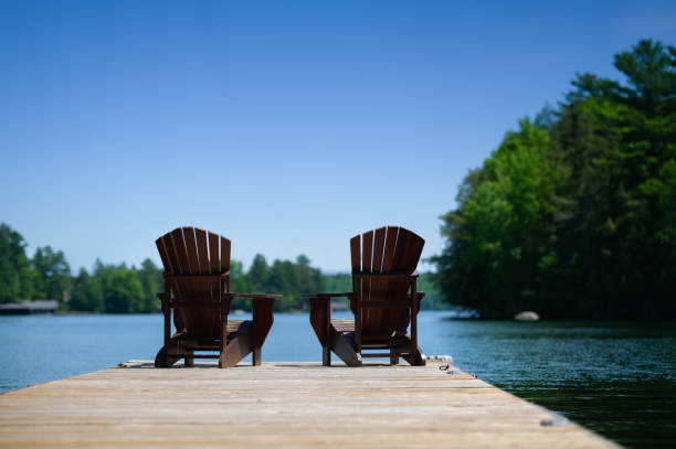 istock Adirondack chairs sitting on a wooden pier 1256422249