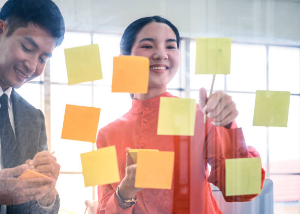 istock Business couple   meeting at office and use post it notes to share idea. 1256423788