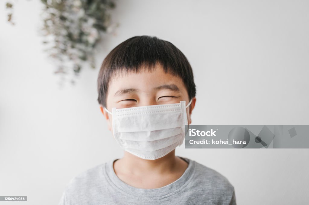 Portrait of boy wearing mask Portrait of Asian boy wearing white surgical mask. Protective Face Mask Stock Photo