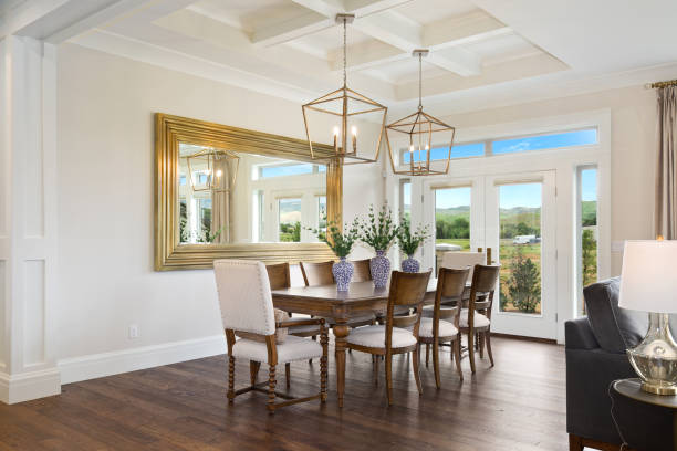High coffered ceiling in formal dining room of large home Staged furnishings in beautiful new luxury home with hardwood flooring light fixture stock pictures, royalty-free photos & images
