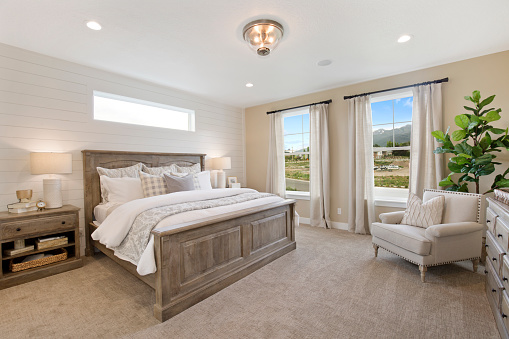 Four-poster bed prepared for guests in a spacious bedroom with a balcony in a vacation rental home