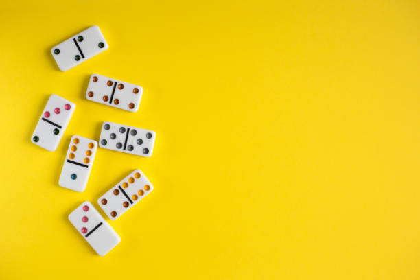 istock White dominoes on yellow background, top view. Board game. Place for text 1256427113